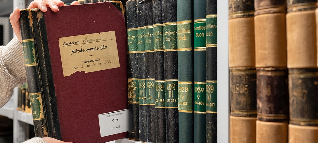 Stadtarchiv Göttingen - Bücherregal, ein Buch wird herausgenommen